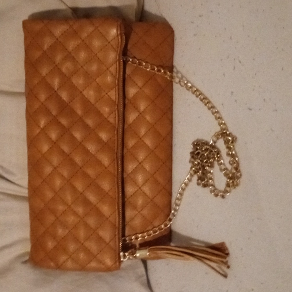 A tan foldable luxurious crossbody with a detachable faux gold chain strap